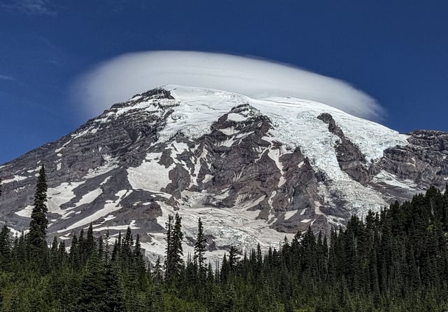 ASA lenticular cloud forms over Mount Rainier, considered an active volcano rising to 14,410 feet above sea level, as viewed from Reflection Lakes on August 29, 2024, near Ashford, Washington.