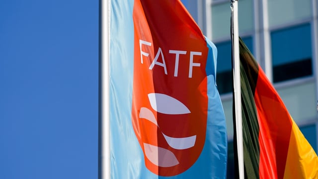 A flag with the logo of the Financial Action Task Force, FATF, waves in the wind next to the German national falg during a meeting of the task force at the Congress Center in Berlin, Germany.