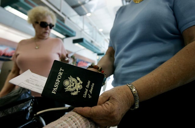 A traveler holds a U.S. passports at San Diego International Airport.