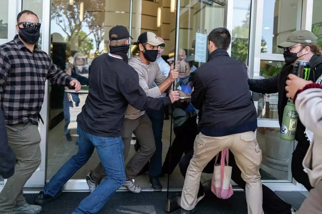 Federal agents attempt to secure the main entrance of the Executive Office for Immigration Review as protesters pursue them at the Concord Immigration Court in Concord in June. On Tuesday a similar scene erupted outside San Francisco&#39;s immigration court.