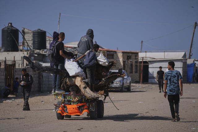 Grupos de desplazados palestinos transportan sus enseres en Rafah