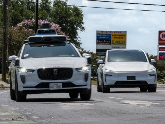 A Waymo autonomous taxi, left, and a vehicle Tesla is using for robotaxi testing purposes in Austin, Texas, US, on Friday, June 20, 2025. Elon Musk said Tesla Inc. has set June 22 as a tentative launch date for the start of its robotaxi network. Photographer: Eli Hartman/Bloomberg