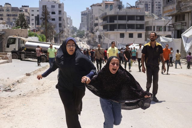 Two girls react after an Israeli strike hit a tent housing displaced Palestinians, in Gaza City, on July 8, 2025.