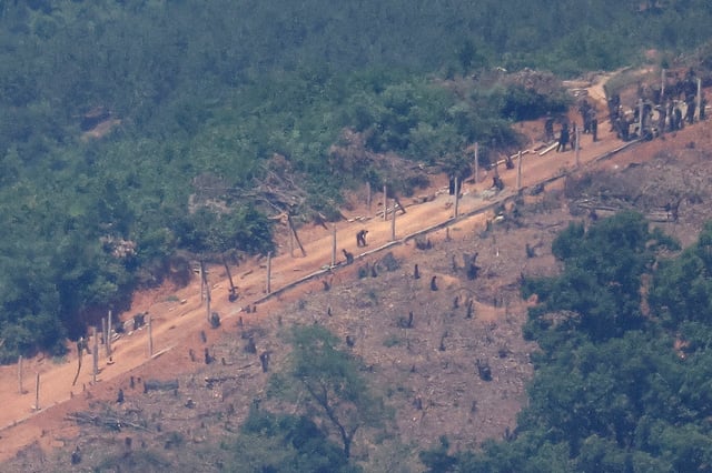 North Korean people work on a military fence near their guard post at the inter-Korean border in this picture taken from the observation deck near the demilitarized zone that separates the two Koreas in Paju, South Korea, June 4, 2024.    REUTERS/Kim Hong-Ji/File Photo