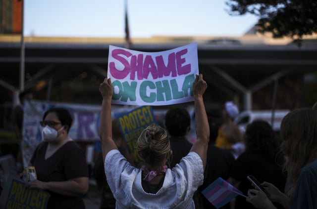 Protesters hold signs while demonstrating against the closure of the trans youth clinic at Children's Hospital Los Angeles, Thursday, July 3, 2025, in Los Angeles. (AP Photo/Jae C. Hong)