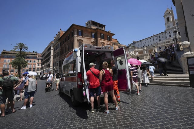 FILE - Paramedics provide aid to tourists and residents with an ambulance, next to the historical Spanish Steps, in Rome, Italy, July 1, 2025. (AP Photo/Andrew Medichini)