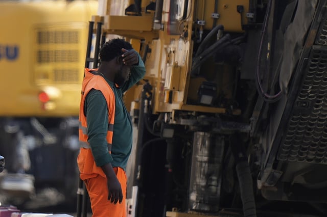 FILE - An employee takes a break as he works at a road construction site in Milan, Italy, July 1, 2025. (AP Photo/Luca Bruno, File)