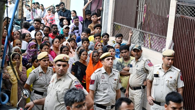 People and Police personnel at the site after a woman named Sonal and an infant (her friend's daughter) were found stabbed to death in the Majnu Ka Tila area, in New Delhi on Tuesday.