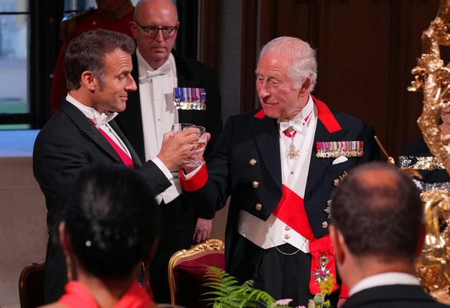Le président français Emmanuel Macron (g) et le roi Charles III trinquent lors d'un dîner d'Etat au château de Windsor, à l'ouest de Londres, le 8 juillet 2025