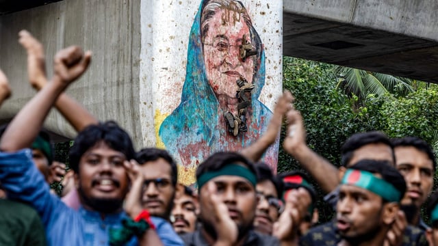 Students chant slogans near a vandalised mural of Bangladesh's ousted Prime Minister Sheikh Hasina, during a protest demanding accountability and trial against Hasina, near Dhaka University 