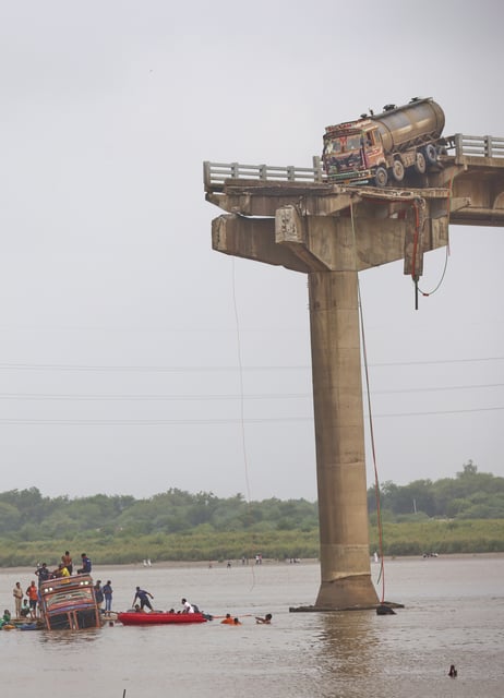 Rescuers and locals look for survivors after several vehicles fell into a river following the collapse of a portion of a bridge in Mujpur near Vadodara in the Indian state of Gujarat, Wednesday, July 9, 2025. (AP Photo)
