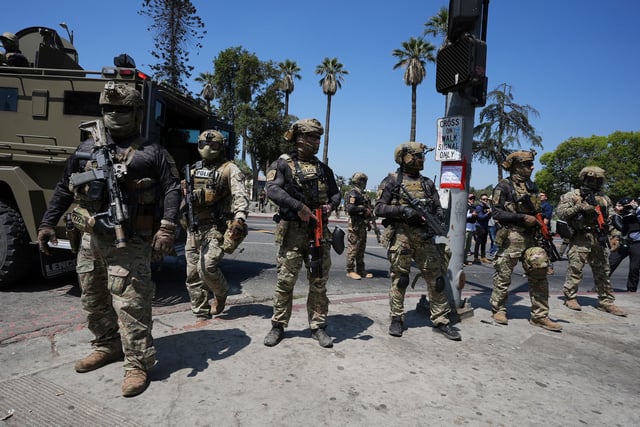 Federal agents stage at MacArthur Park in Los Angeles on Monday.