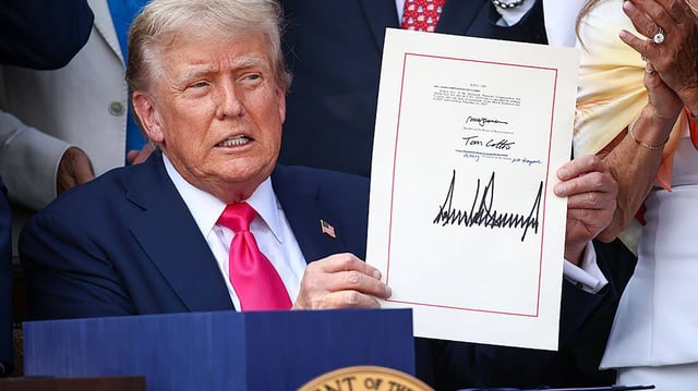 U.S. President Donald Trump, joined by Republican lawmakers, signs the One, Big Beautiful Bill Act into law during an Independence Day military family picnic on the South Lawn of the White House on July 4, 2025, in Washington, D.C. (Samuel Corum/Getty Images/TNS)