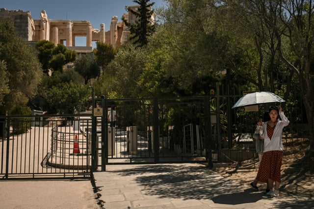 Une touriste devant l'entrée fermée de l'Acropole à Athènes, le 8 juillet 2025 en Grèce