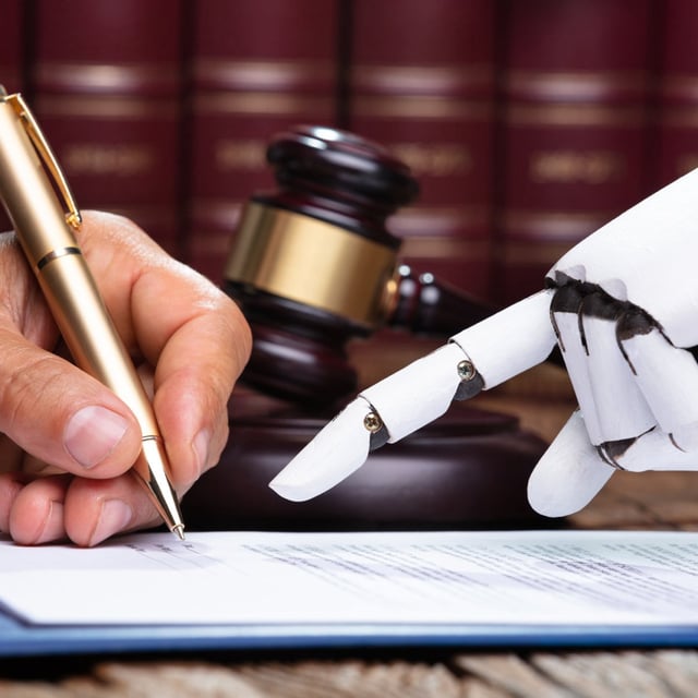 A robotic hand pointing to a human hand signing a document.