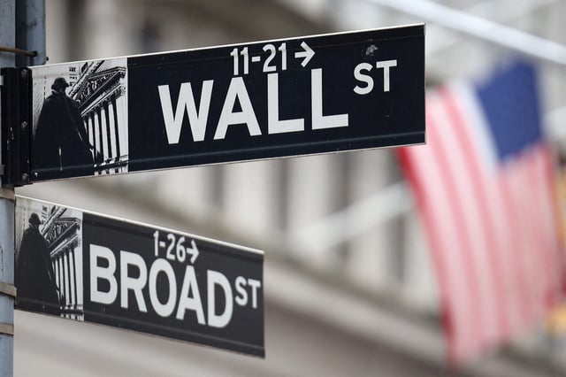 FILE PHOTO: A Wall Street sign hangs in front of a U.S. flag outside the New York Stock Exchange in New York City, U.S., September 18, 2024. REUTERS/Andrew Kelly/File Photo