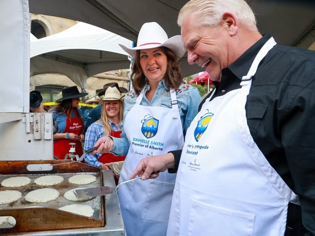Alberta Premier Danielle Smith and Ontario Premier Doug Ford cook pancakes at the annual Premier's Stampede Breakfast at McDougall Centre in Calgary on Monday, July 7, 2025.