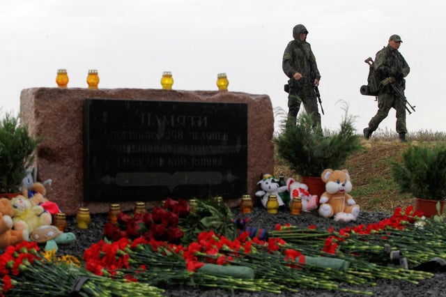 Members of the self-proclaimed Donetsk People's Republic forces walk past a memorial to victims of Malaysia Airlines Flight MH17 plane crash, that was shot down over rebel-held territory in 2014, on the anniversary of the incident, outside the village of Hrabove in Donetsk region, Ukraine July 17, 2020.  REUTERS/Alexander Ermochenko/File Photo