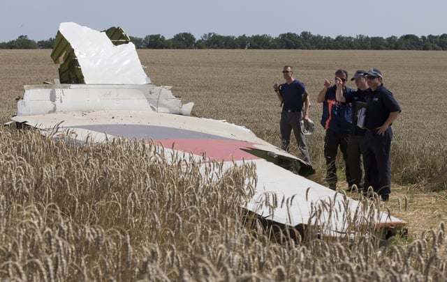 FILE - In this Friday, Aug. 1, 2014 file photo, Australian and Dutch investigators examine a piece of the Malaysia Airlines Flight 17 plane, near the village of Hrabove, Donetsk region, eastern Ukraine. The Dutch government is taking to Russia to the European Court of Human Rights for its alleged role in the shooting down of Malaysia Airlines Flight 17 over eastern Ukraine six years ago, the foreign minister announced Friday July 10, 2020.