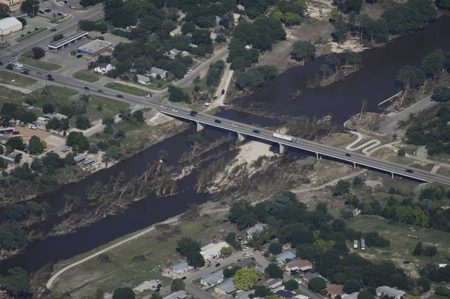 Cars pass a bridge over the Guadalupe River on Tuesday, July 8, 2025, after a flash flood swept through the area in Kerrville, Texas. (AP Photo/Ashley Landis)