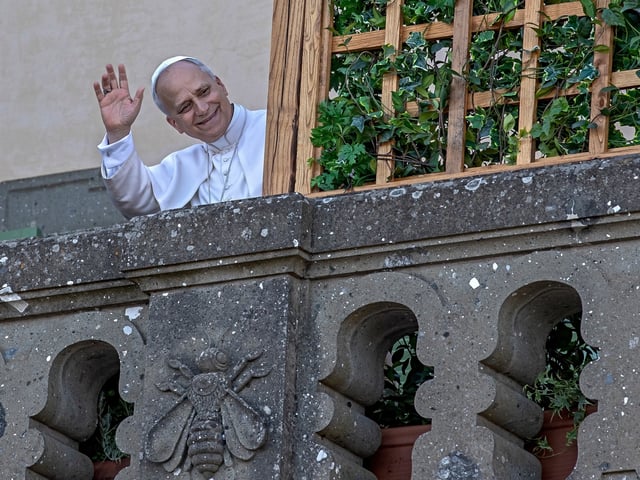 Pope Leo XIV, newly elected, waves to the people from the terrace of the summer papal estate in Castel Gandolfo, approximately 40 kilometers southeast of Rome, on July 6, 2025. This two-week sojourn marks the revival of a longstanding papal tradition that had been temporarily suspended during the pontificate of Pope Francis. Castel Gandolfo eagerly anticipates the arrival of a pope for the first time in over a decade. (Photo by Maria Grazia Picciarella / Middle East Images via AFP)