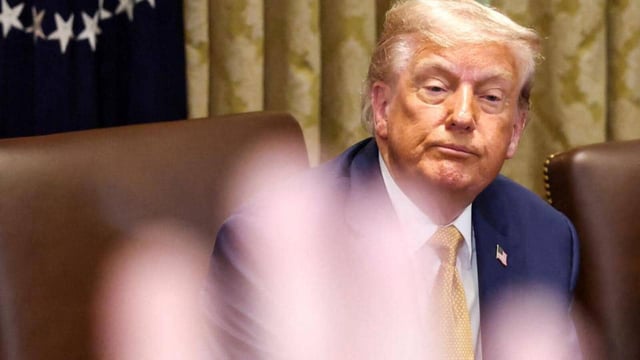 A reporter raises a hand to ask a question as US President Donald Trump attends a cabinet meeting at the White House in Washington, D.C. (REUTERS)