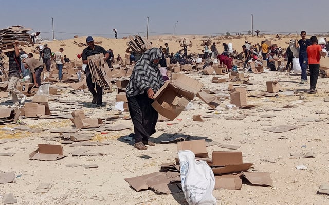 FILE PHOTO: Palestinians gather to collect what remains of relief supplies from the distribution center of the U.S.-backed Gaza Humanitarian Foundation, in Rafah, in the southern Gaza Strip, June 5, 2025. REUTERS/Stringer/File Photo/File Photo