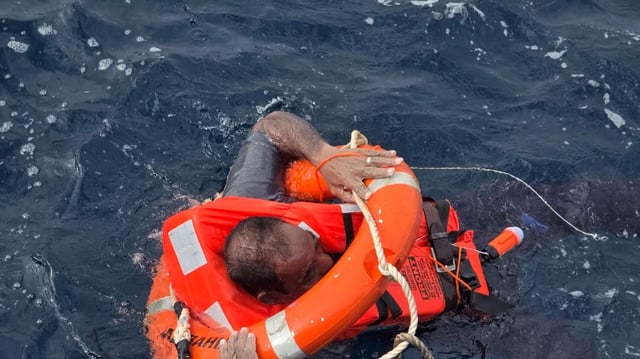 Menschen, die offenbar Crewmitglieder der "Eternity" waren, bringen sich mit Rettungsringen und Schwimmwesten in Sicherheit