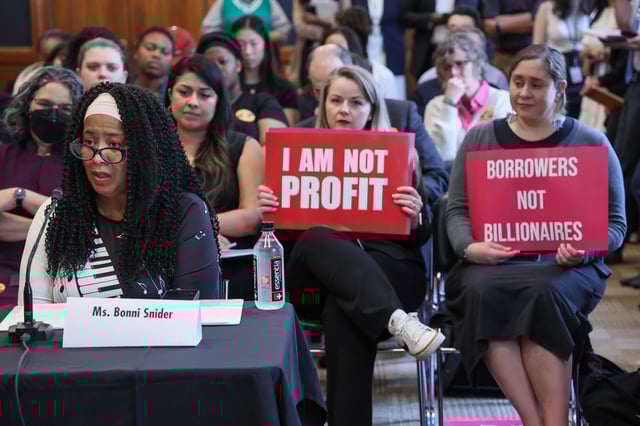 Audience members hold signs behind veteran and student loan borrower Bonni Snider as she testifies during a special forum on the rising cost of education at the Dirksen Senate Office Building on May 14, 2025 in Washington, DC.