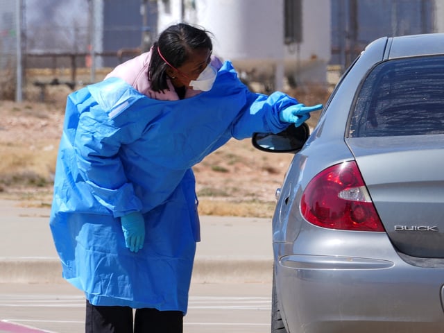 FILE - A health worker talks to people before administering measles tests outside Seminole Hospital District, Feb. 21, 2025, in Seminole, Texas. (AP Photo/Julio Cortez, File)