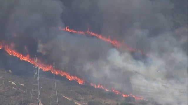 Smoke billows into the air from a brush fire in Jamul, July 9, 2025.