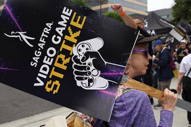 A person holds a sign as she takes part in a SAG-AFTRA Video Game Strike picket outside Warner Bros. Games in Burbank, California, U.S. October 16, 2024.  REUTERS/Mario Anzuoni/File Photo
