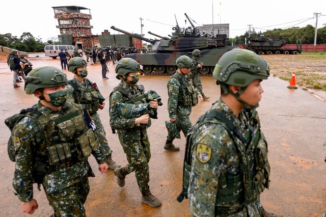 Soldiers walk past U.S.-made M1A2T Abrams tanks as they take part in live-fire exercises in Hsinchu, Taiwan July 10, 2025. REUTERS/Ann Wang