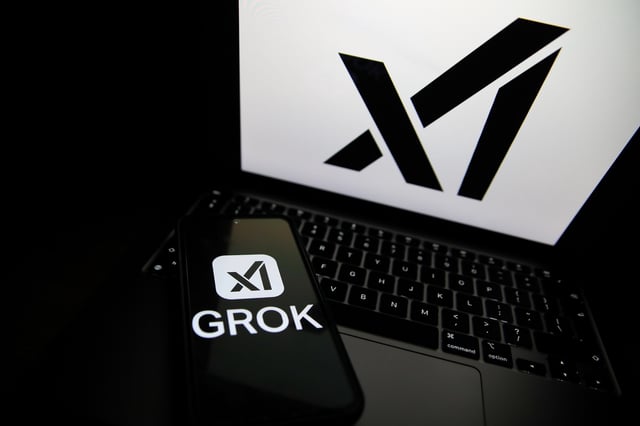 The Grok logo appears on a phone and the xAI logo is displayed on a laptop in Krakow, Poland, on April 1, 2025. (Photo by Klaudia Radecka/NurPhoto)