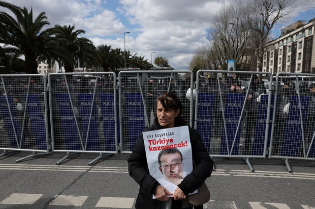 A woman holds a placard with the picture of Istanbul Mayor Ekrem Imamoglu as his supporters gather near the city's police headquarters in Istanbul, Turkey, March 19, 2025. REUTERS/Umit Bektas/File Photo