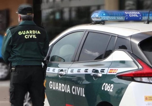 Imagen de archivo de un agente de la Guardia Civil junto a su coche patrulla