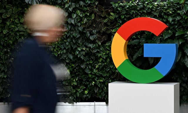 Una dona passeja davant un logo de Google al costat de la seu d’aquesta empresa a Varsòvia. | SERGEI GAPON / AFP