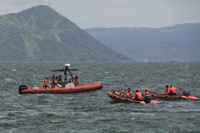 Philippine Coast Guard personnel prepare to depart to the site where the bodies of cockfighters were allegedly dumped in Lake Taal, south of Manila