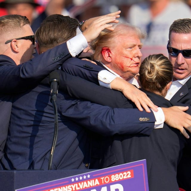 Der republikanische Präsidentschaftsbewerber und frühere US-Präsident Donald Trump wird von Agenten des US-Geheimdienstes Secret Service umringt, als ihm bei einer Wahlkampfveranstaltung von der Bühne geholfen wird.