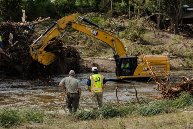 Search and recovery crews use a large excavator to remove debris from the bank of the Guadalupe River in Center Point, Texas, on Wednesday.