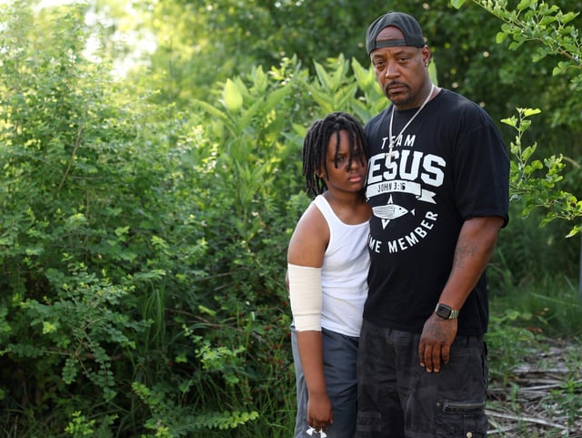 Dion Wallace and his 10-year-old son stand outside a relative&#39;s home in Round Lake on July 9, 2025. Prosecutors say the boy&#39;s mother, Wendy Tolbert, stabbed him with a knife on the arm, fatally stabbed his brother, 4, and critically injured their stepsister, 13, before setting their apartment on fire in the 3600 block of West Palmer Street on July 4. (John J. Kim/Chicago Tribune)