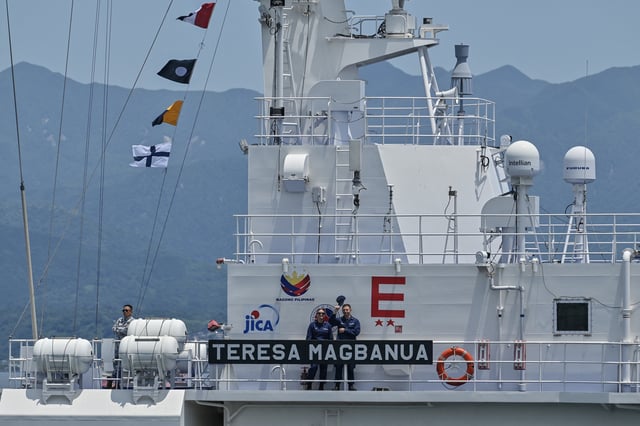 Crew members of the Philippine Coast Guard ship Teresa Magbanua wave during exercises with the United States Coast Guard ship Cutter Stratton and the Japan Coast Guard ship Asanagi in the waters around the southern city of Kagoshima, Kagoshima prefecture on June 20, 2025.