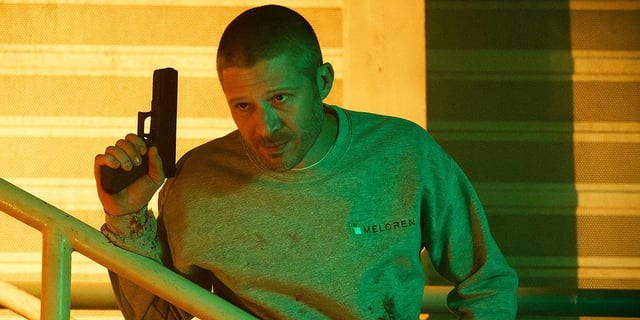 Voit (Zach Gilford) holding a gun up and looking over a railing in Criminal Minds: Evolution Season 3