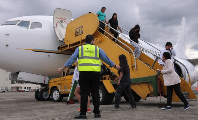 People deported from the United States disembark a repatriation flight during a Department of Homeland Security operations tour for visiting Homeland Security Secretary Kristi Noem, at La Aurora International Airport in Guatemala City, Thursday, June 26, 2025. (Anna Moneymaker/Pool Photo via AP)