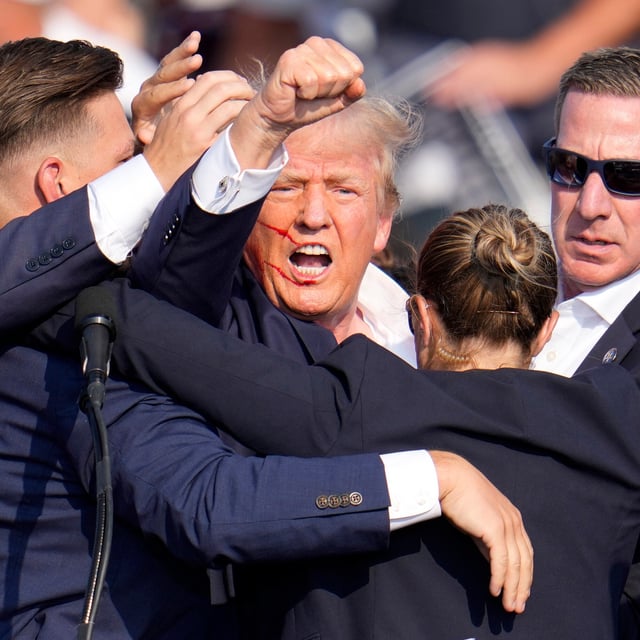 Donald Trump wird kurz nach den Schüssen verletzt von der Bühne geführt.