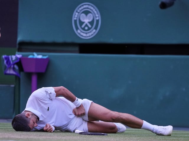 Serbia's Novak Djokovic reacts after slipping and falling when attempting a return to Italy's Flavio Cobolli during a quarterfinal men's singles match at the Wimbledon Tennis Championships in London, Wednesday, July 9, 2025. (AP Photo/Kin Cheung)