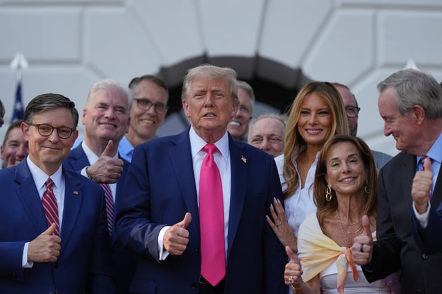 President Donald Trump poses for a photo after signing his signature bill of tax breaks and spending cuts at the White House, Friday, July 4, 2025, in Washington, surrounded by members of Congress, including House Speaker Mike Johnson of La., left. (AP Photo/Julia Demaree Nikhinson)