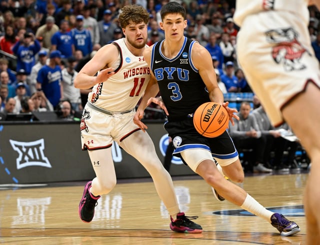 Brigham Young guard Egor Demin, right, drives past Wisconsin guard Max Klesmit during the first half in the second round of the NCAA college basketball tournament Saturday, March 22, 2025, in Denver. (AP Photo/John Leyba)