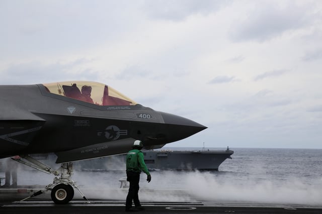 United States Seventh Fleet prepares a F-35 stealth fighter for take-off aboard USS Carl Vinson flanked by Japan’s helicopter carrier Hyuga, in the Pacific Ocean November 11, 2023.