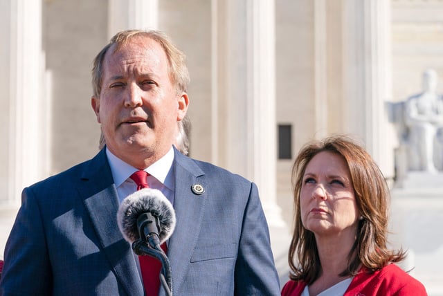 In this November 2021 photo, Texas State Sen. Angela Paxton, right, listens as her husband Texas Attorney General Ken Paxton, center, speaks to anti-abortion activists at a rally outside the Supreme Court in Washington, DC.